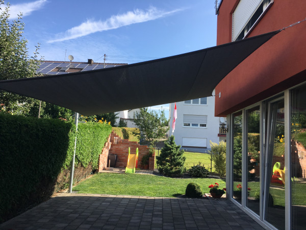 Dunkles, viereckiges Sonnensegel über Terrasse