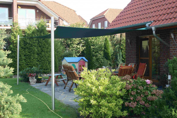 Grünes Segeltuch mit zwei Pfosten und Wandbefestigung über einer Terrasse